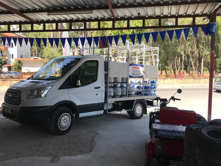 Kapalı servis alanında bekleyen ticari araç ve yanında istiflenmiş lastikler