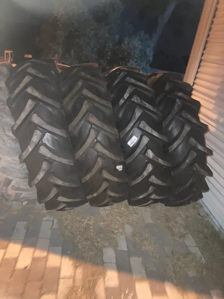 Derin tırnaklı yeni traktör lastikleri dükkân önünde sıralanmış