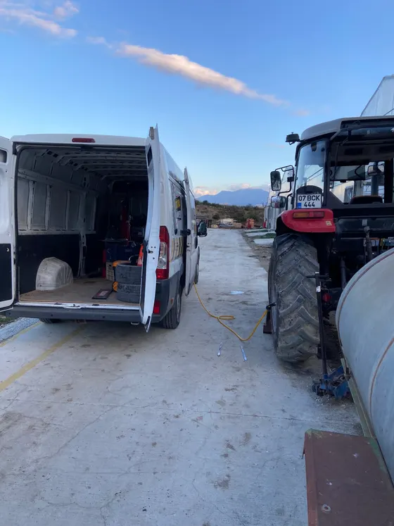 Mobil servis aracı bir traktörün yanına yanaşmış, sahada lastik değişimi yapılıyor